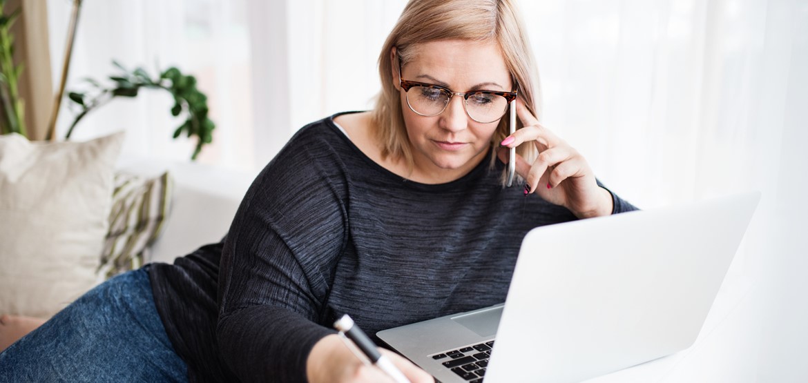 Woman on phone and laptop trying to manage her debt