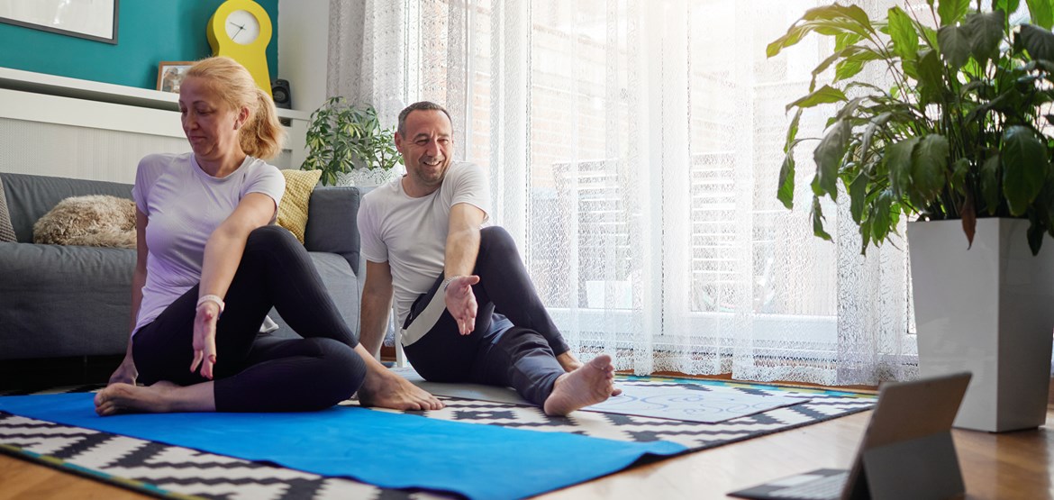 Man and woman doing yoga at home