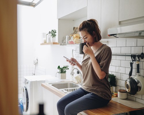 Woman drinking coffee and looking at phone