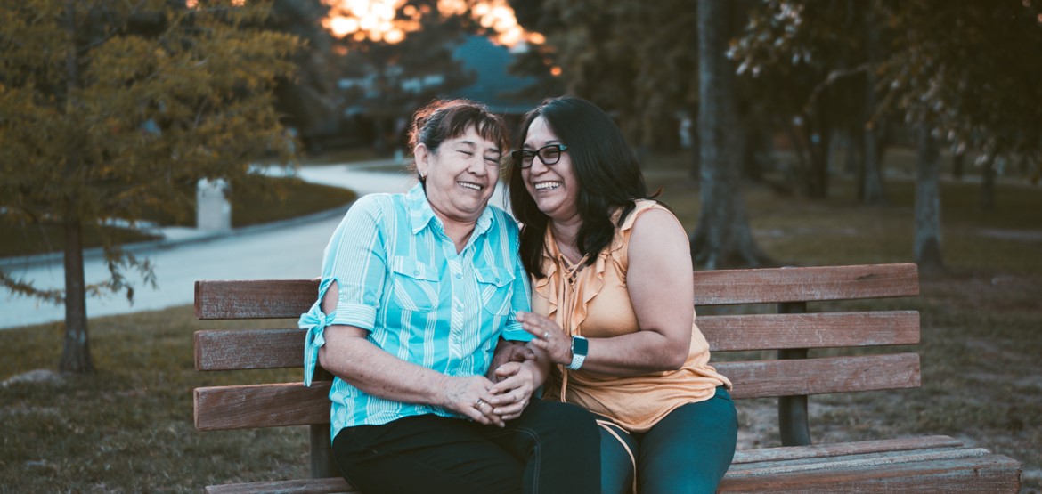 Women hugging on a bench