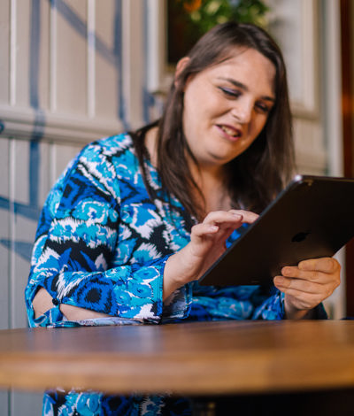 Woman sitting at a table using a tablet