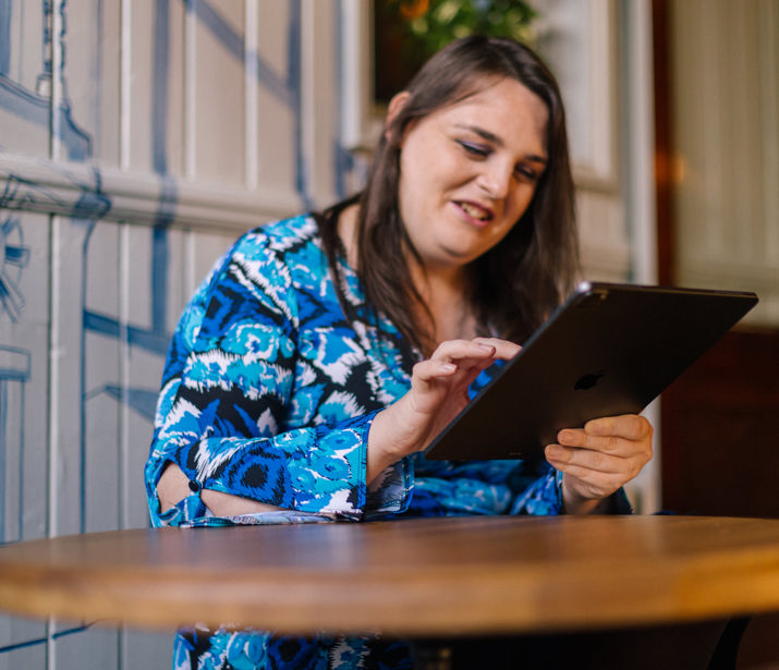 Woman sitting at a table using a tablet