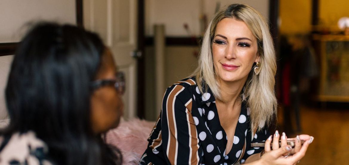 Person listening to friend talking on sofa.