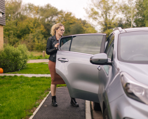A woman opening a car door