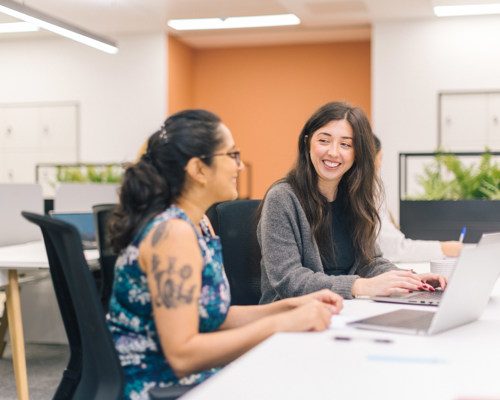 Two people working having a conversation in an office