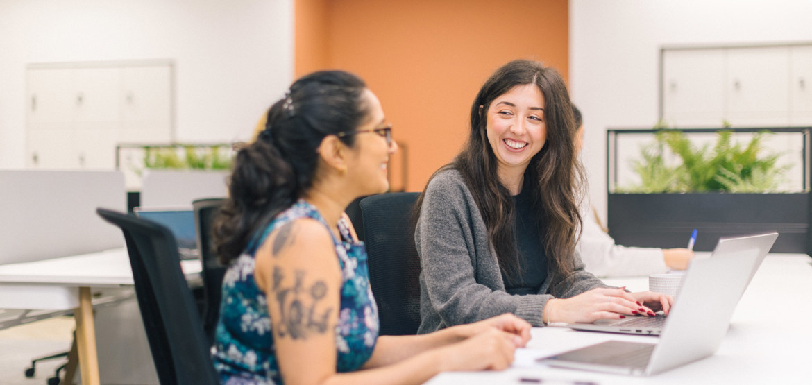 Two people working having a conversation in an office