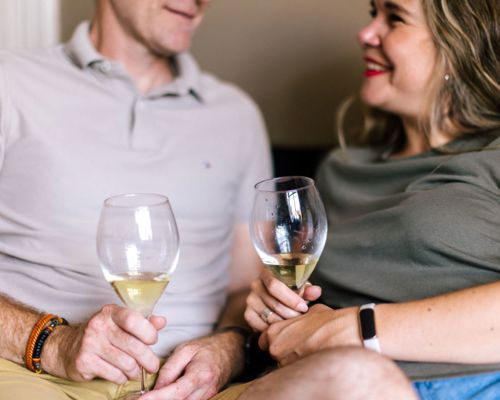 Couple Holding Wine Glasses At Home Drinking