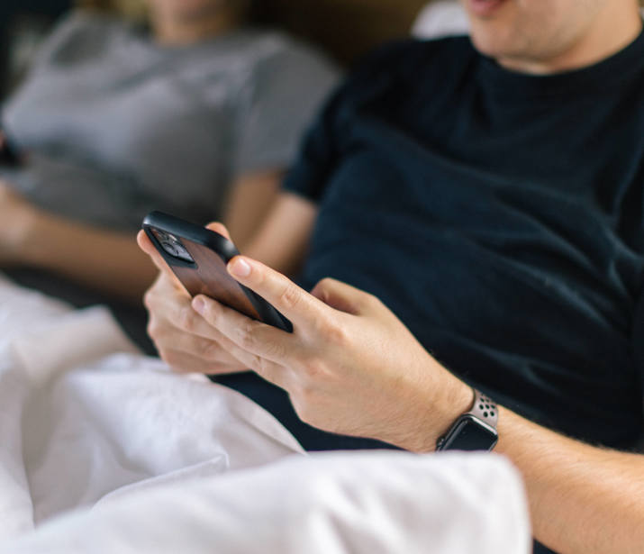 A couple in bed on their phones