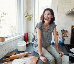 Woman sat in kitchen making pastry