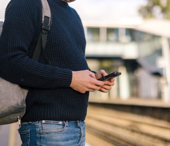 Person stood on train platform checking their phone.