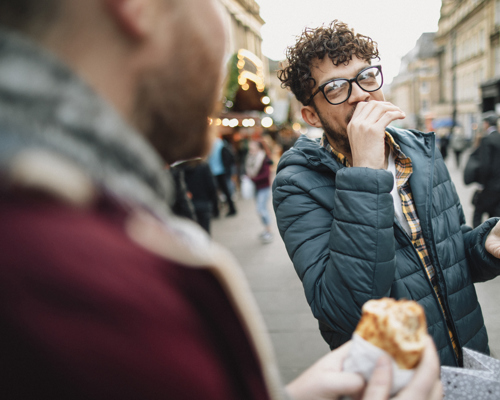 A male couple at an outside food market