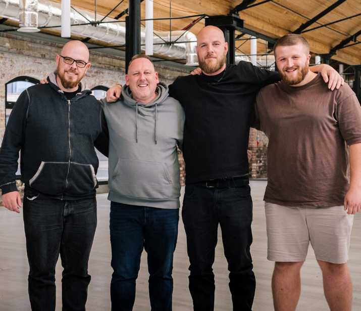 A group of men standing together in a line with their arms around each other