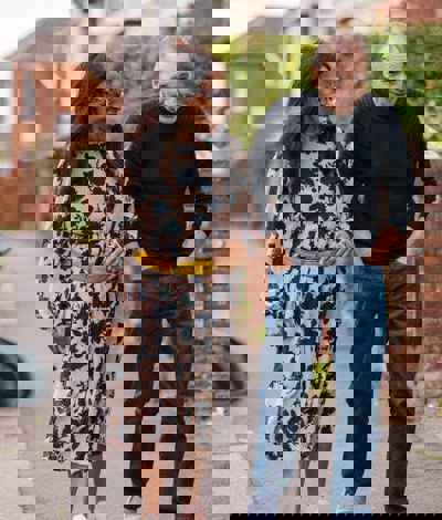 A man and a woman walking down a suburban street talking