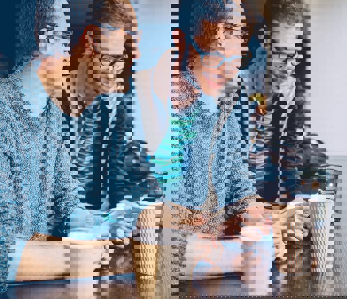 Two men having coffee looking at phones