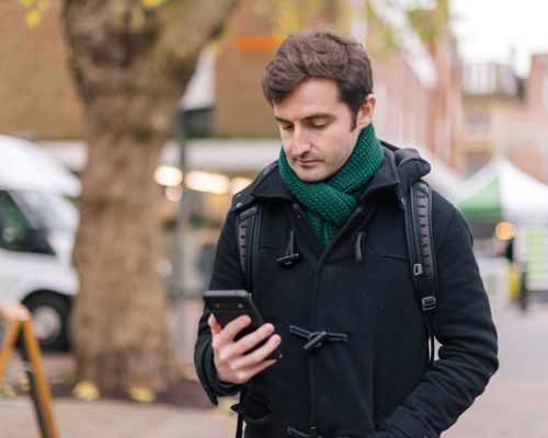Person Looking At Phone In Street Technology