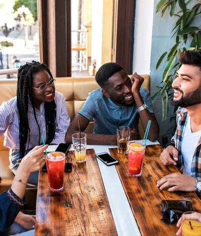 Group of young people talking around a table with soft drinks