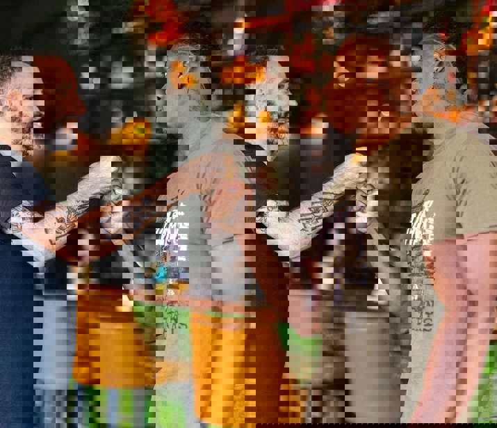 Two men fist-bumping in a social setting