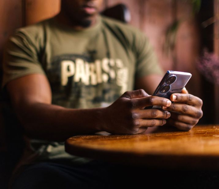 Close up of a person holding their phone in a pub.