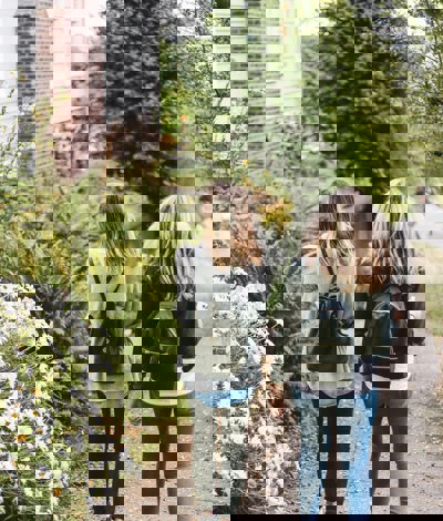 Two teenage girls walking down a hilly street