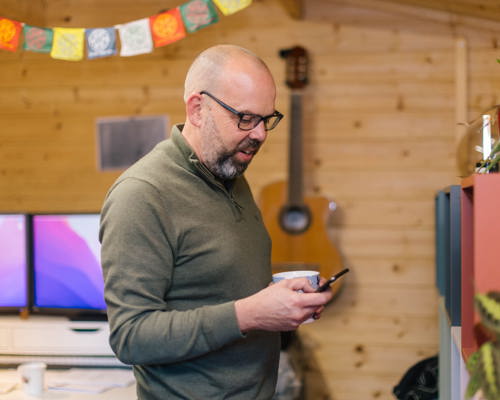 man wearing glasses looking on his phone