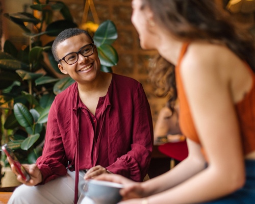 Two people chatting and sitting in a social setting