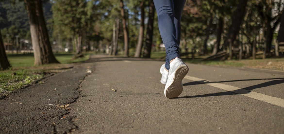 Woman running, view of feet and road