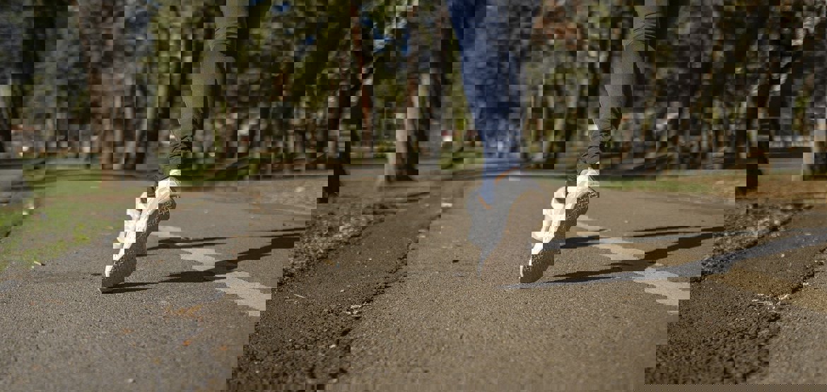 Woman running, view of feet and road