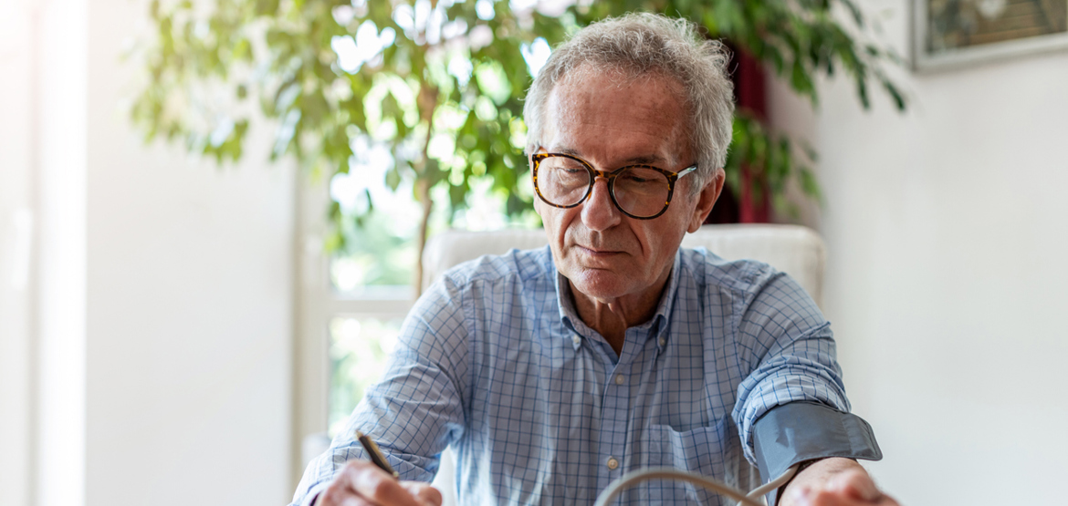 Man checking his blood pressure and making notes