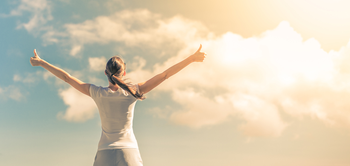 Woman with thumbs up looking at the sky