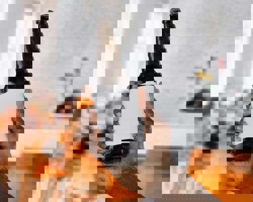 A hand holding a bottle with a blank label on it