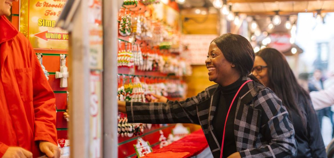 Person shopping for Christmas ornaments at a Christmas market.
