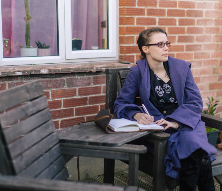 Woman sat on bench with notebook