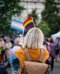 Woman holding Pride and Trans flags